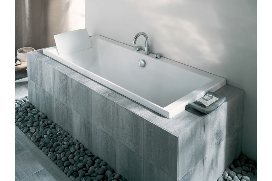 Une baignoire avec un tablier en carrelage sur-mesure gris foncé
