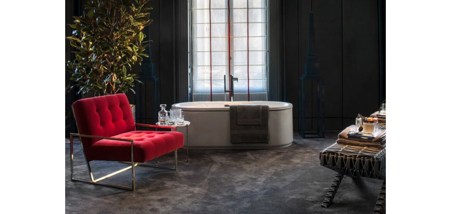 Un fauteuil rouge velours design dans une grande salle de bains chic