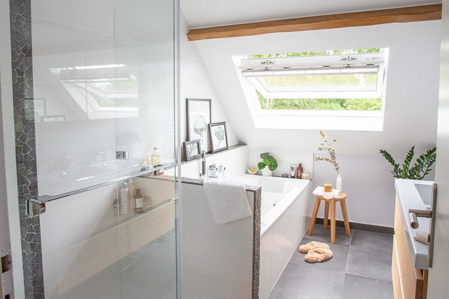 Une salle de bains lumineuse rénovée avec une baignoire, une douche et une double vasque avec meuble sous plan-vasque en bois