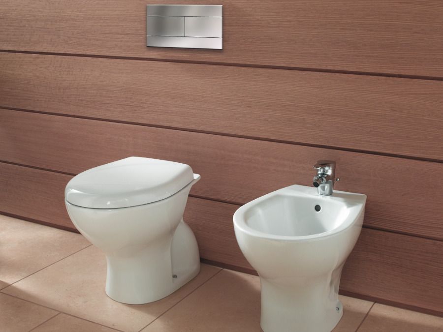 Bidet et WC dans une salle de bains avec un mur en bois